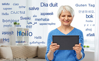 Image showing senior woman using translator on tablet computer