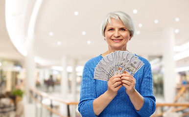 Image showing senior woman with dollar money over shopping mall