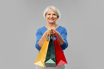 Image showing senior woman with shopping bags over grey