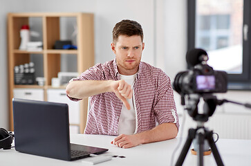 Image showing male blogger with camera videoblogging at home