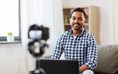 Image showing male blogger with camera videoblogging at home