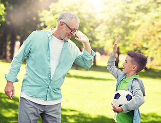 Image showing old man and boy with soccer ball making high five