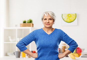 Image showing senior woman with hands on hips in kitchen