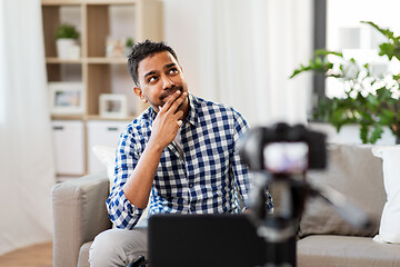 Image showing male blogger with camera videoblogging at home