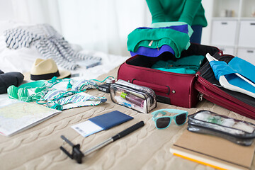 Image showing woman packing travel bag at home or hotel room