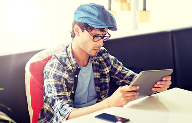 Image showing man with tablet pc sitting at cafe table