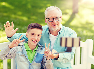 Image showing old man and boy taking selfie by smartphone