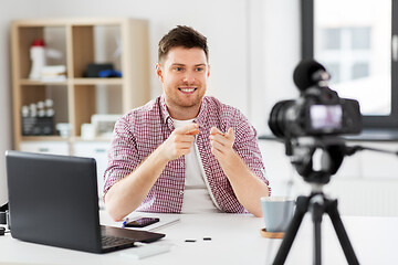 Image showing male blogger with camera videoblogging at home