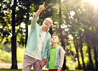 Image showing grandfather and boy pointing up at summer park