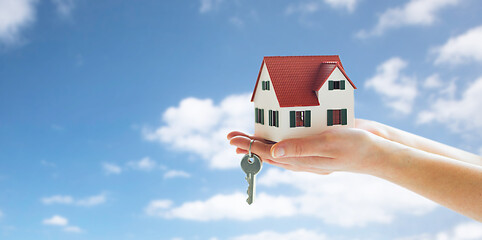 Image showing close up of hands holding house model and keys