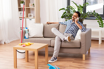 Image showing man calling on smartphone after cleaning home