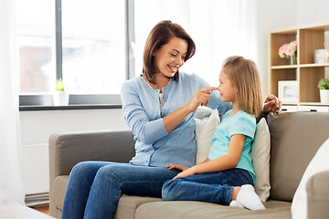 Image showing mother and daughter sitting on sofa at home