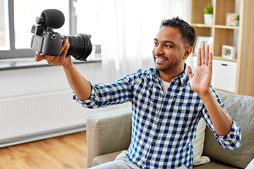 Image showing male video blogger with camera blogging at home