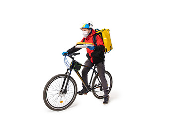 Image showing Too much orders. Contacless delivery service during quarantine. Man delivers food and shopping bags during isolation, wearing gloves and face mask.