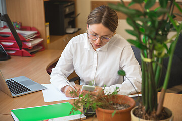 Image showing Caucasian entrepreneur, businesswoman, manager working concentrated in office