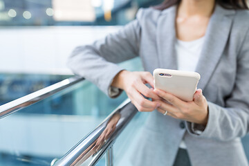 Image showing Businesswoman sending text message on mobile phone