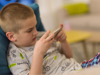 Image showing little boy playing games on smartphone