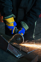 Image showing worker cutting metal with grinder