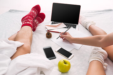 Image showing caucasian couple at home using internet technology LLaptop and phone for people sitting on the floor