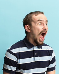 Image showing The man screaming with open mouth isolated on blue background, concept face emotion