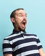 Image showing The man screaming with open mouth isolated on blue background, concept face emotion