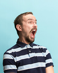 Image showing The man screaming with open mouth isolated on blue background, concept face emotion