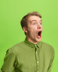 Image showing The man screaming with open mouth isolated on green background, concept face emotion