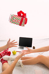 Image showing caucasian couple at home with gift. Laptop and phone for people sitting on the floor