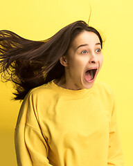 Image showing The woman screaming with open mouth isolated on yellow background, concept face emotion