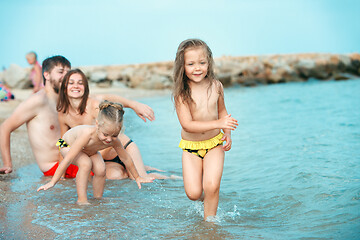 Image showing Happy family enjoying walk on the beach