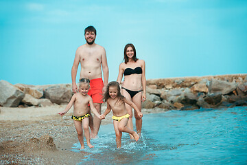 Image showing Happy family enjoying walk on the beach