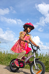 Image showing Cute girl cycling with a princess outfit