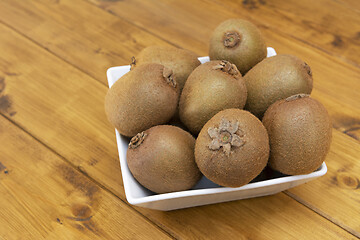 Image showing Eight hairy kiwi fruit in a white china bowl