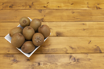 Image showing Fresh kiwi fruits piled in a bowl on a table