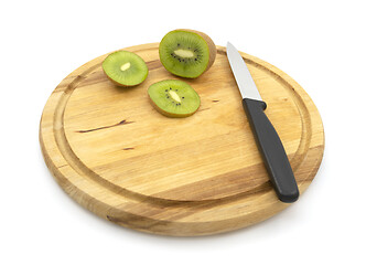 Image showing Fresh kiwi sliced with knife, with slices on wooden board 