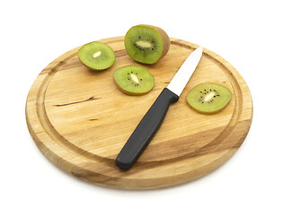 Image showing Kitchen knife used to cut slice of healthy kiwi fruit