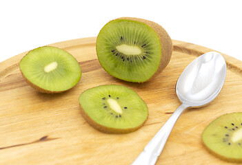 Image showing Sliced healthy kiwifruit with a spoon on a wooden board