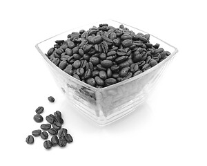 Image showing Glass dish filled with coffee beans, some spilled beside