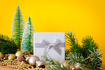 Image showing Christmas decoration glass balls with fir trees on yellow backgr