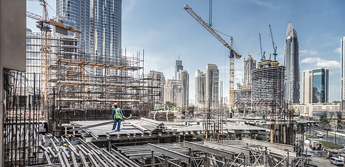 Image showing Laborers working on modern constraction site works in Dubai. Fast urban development consept