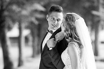 Image showing Bride and groom hugging tenderly posing during photo shooting in park.