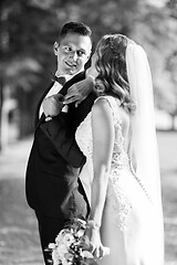 Image showing Bride and groom hugging tenderly posing during photo shooting in park.