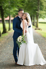 Image showing Bride and groom hugging tenderly posing during photo shooting in park.