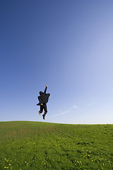 Image showing Businessman jumping on the field