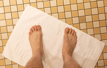 Image showing After taking a shower; Male feet on a vintage bathroom floor