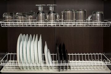 Image showing Clean plates and cups are neatly located in kitchen cupboard