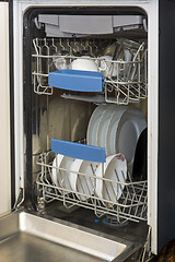 Image showing Dishwasher at home kitchen with clean plates, cups, spoons and forks in it