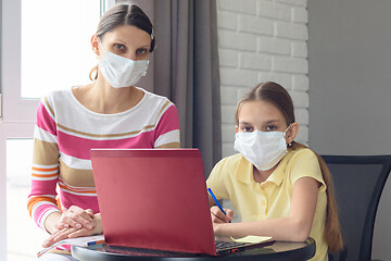 Image showing Ill mother and child are sitting at the table and looked at the cad