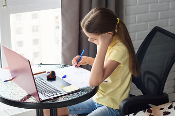 Image showing Girl at home doing online lessons while sitting at the computer