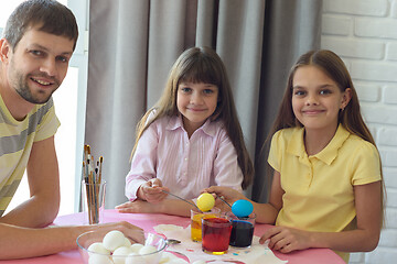Image showing The children, together with dad, painted the first Easter eggs and looked joyfully into the frame